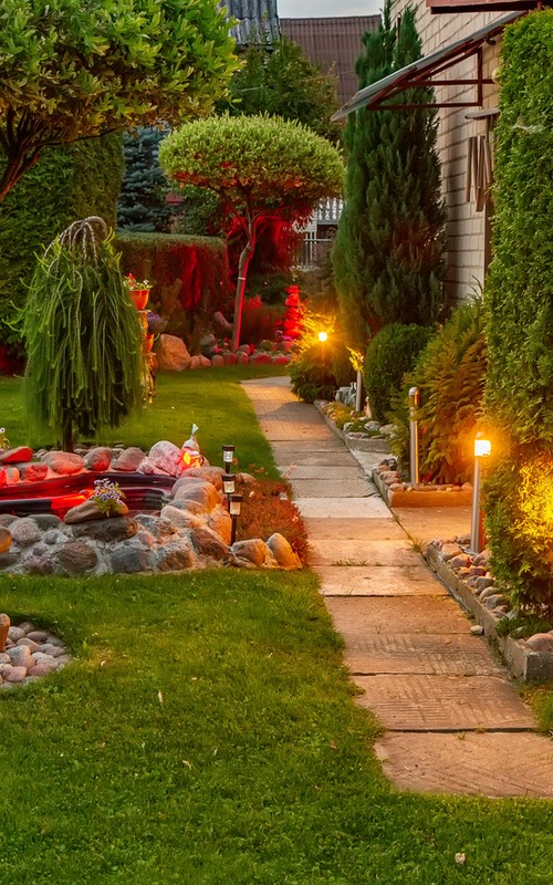 A beautiful lit yard during dusk, provided by Hot Shot Sprinkler Repair & Landscape a landscaping company in Utah & Arizona.