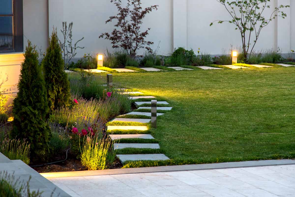 A beautiful yard being lit up by lighting fixtures.