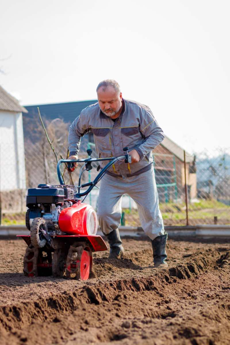 Man tilling his yard preparing for Hot Shot's sod installation services.